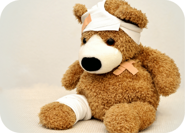 Teddy bear with bandage on its head and leg